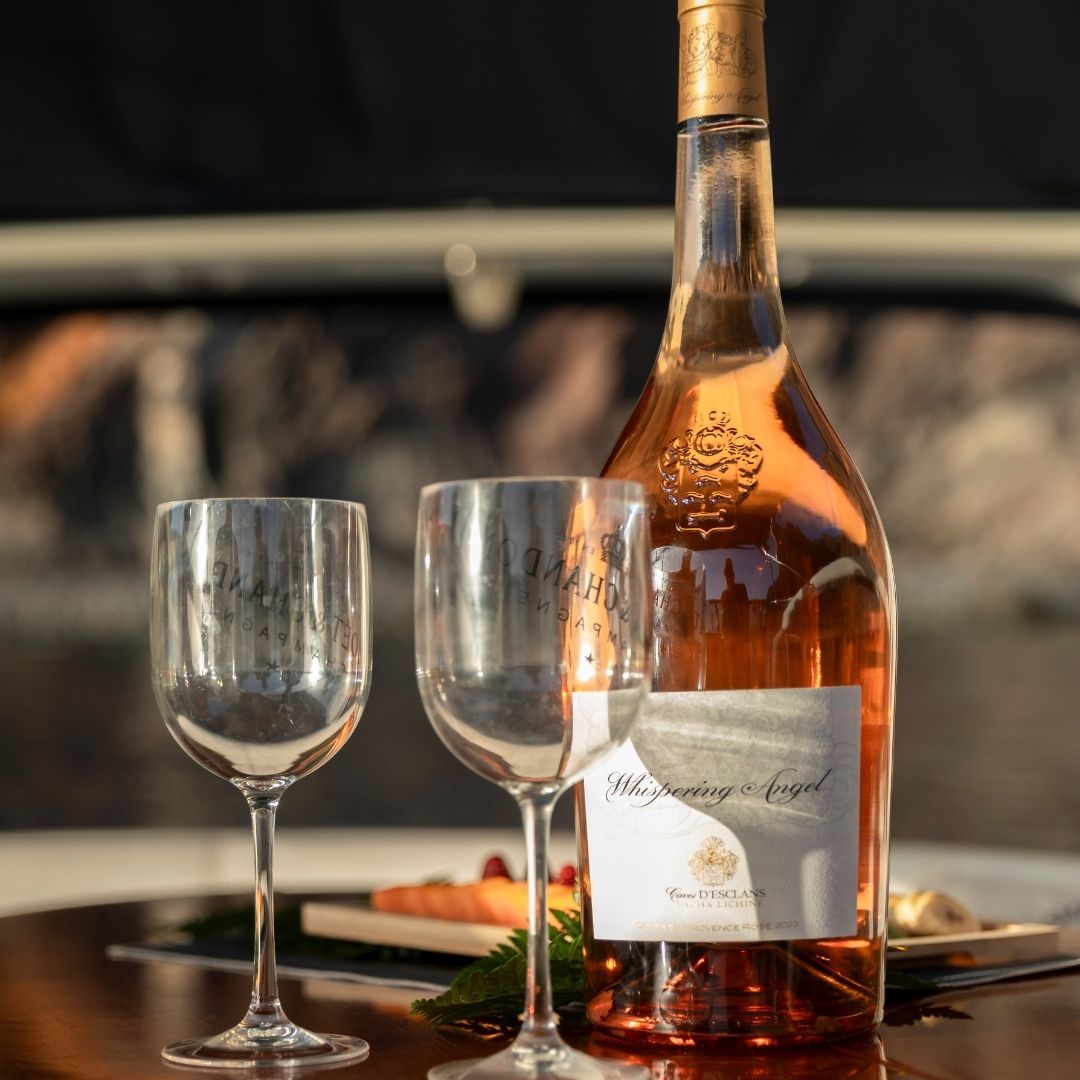 Botella de rosado y dos copas en cubierta